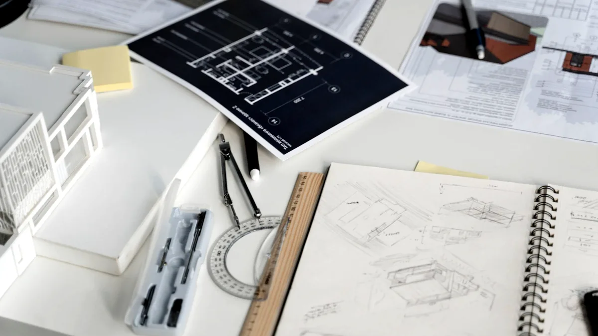 Работно място на интериорен дизайнер с чертежи и мостри.